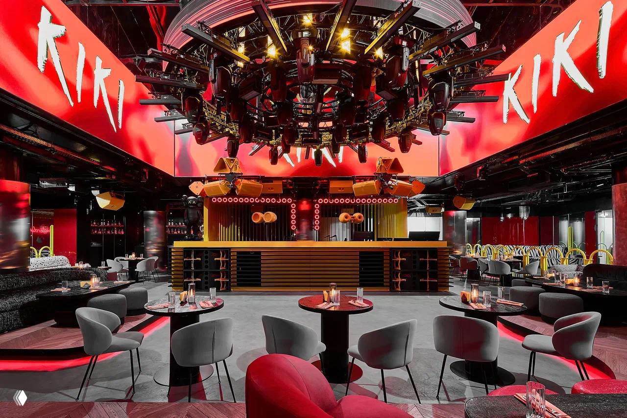 Главный зал KiKi Event Dom: танцпол, круглая световая конструкция над баром, столики и лаунжи в насыщенной красно‑чёрной гамме для мероприятий.