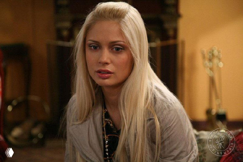 Портретный кадр блондинки в интерьере: крупный план лица и плеч, драматичное выражение; сцена из российского сериала.