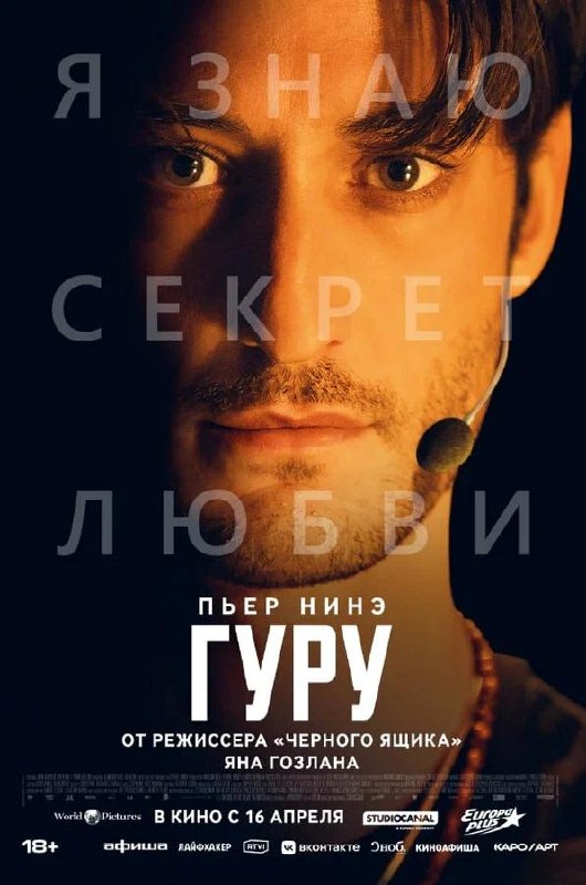 Постер фильма «Гуру»: крупный план лица актёра в гарнитуре-микрофоне на тёмном фоне, атмосферный портретный постер премьеры с напряжённым взглядом.