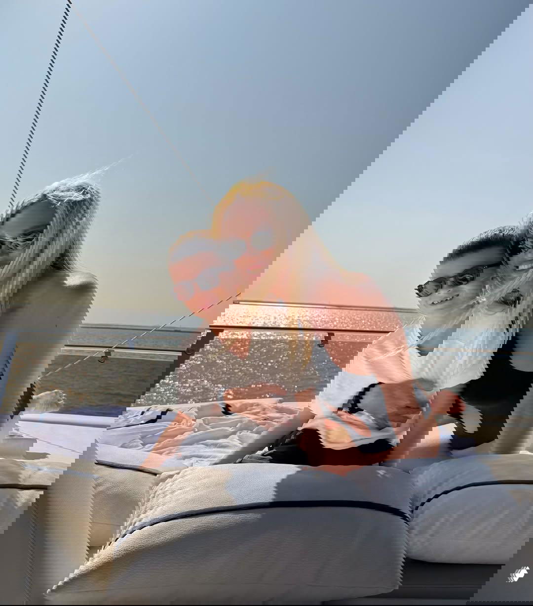 Виктория Лопырева улыбается вместе с сыном Марком на палубе яхты; мальчик в белой футболке, позируют на фоне моря.