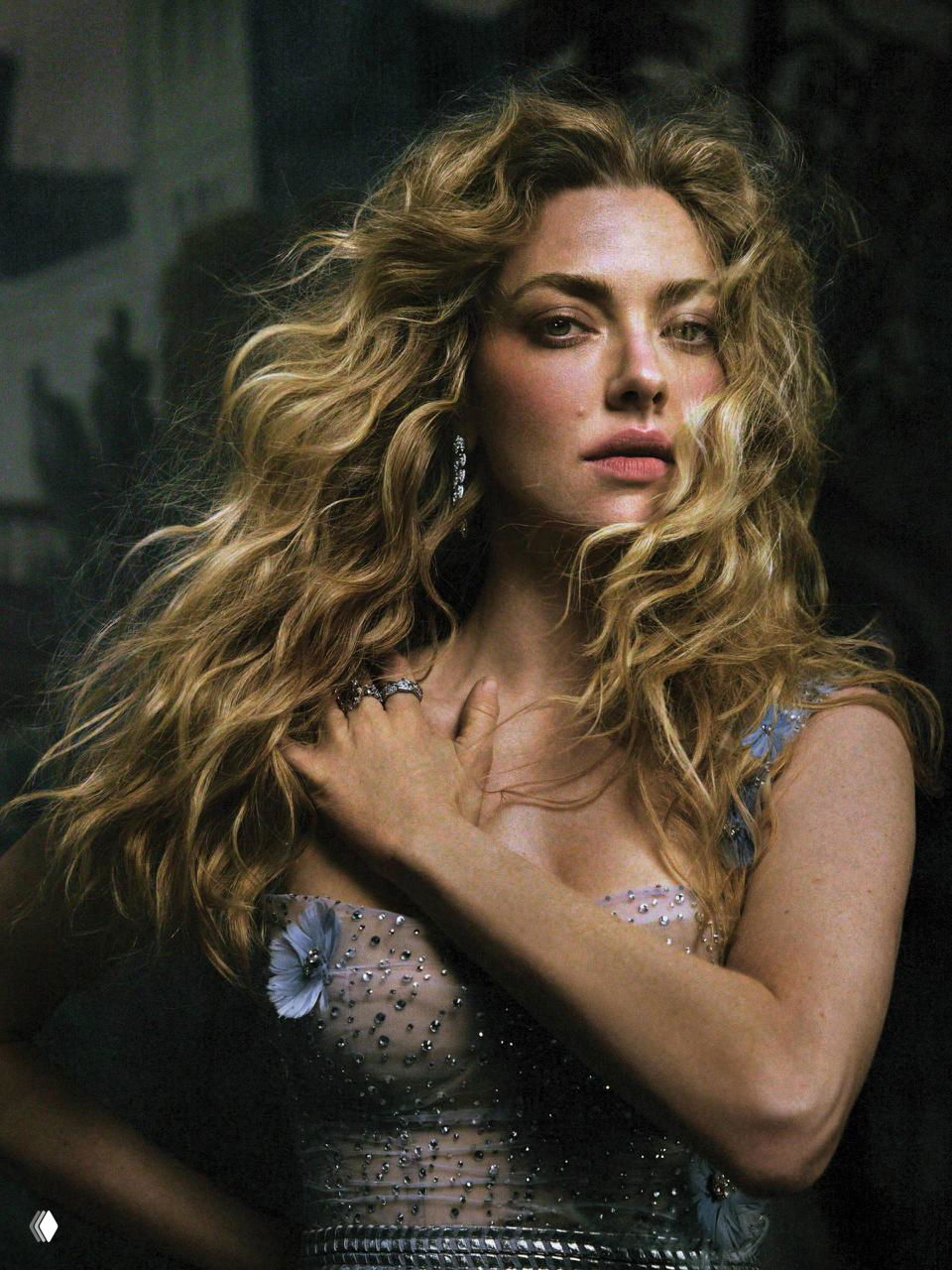 Портретный план: женщина с распущенными вьющимися волосами и лёгким макияжем, драматичное освещение, украшения и детализированная съёмка в студии.