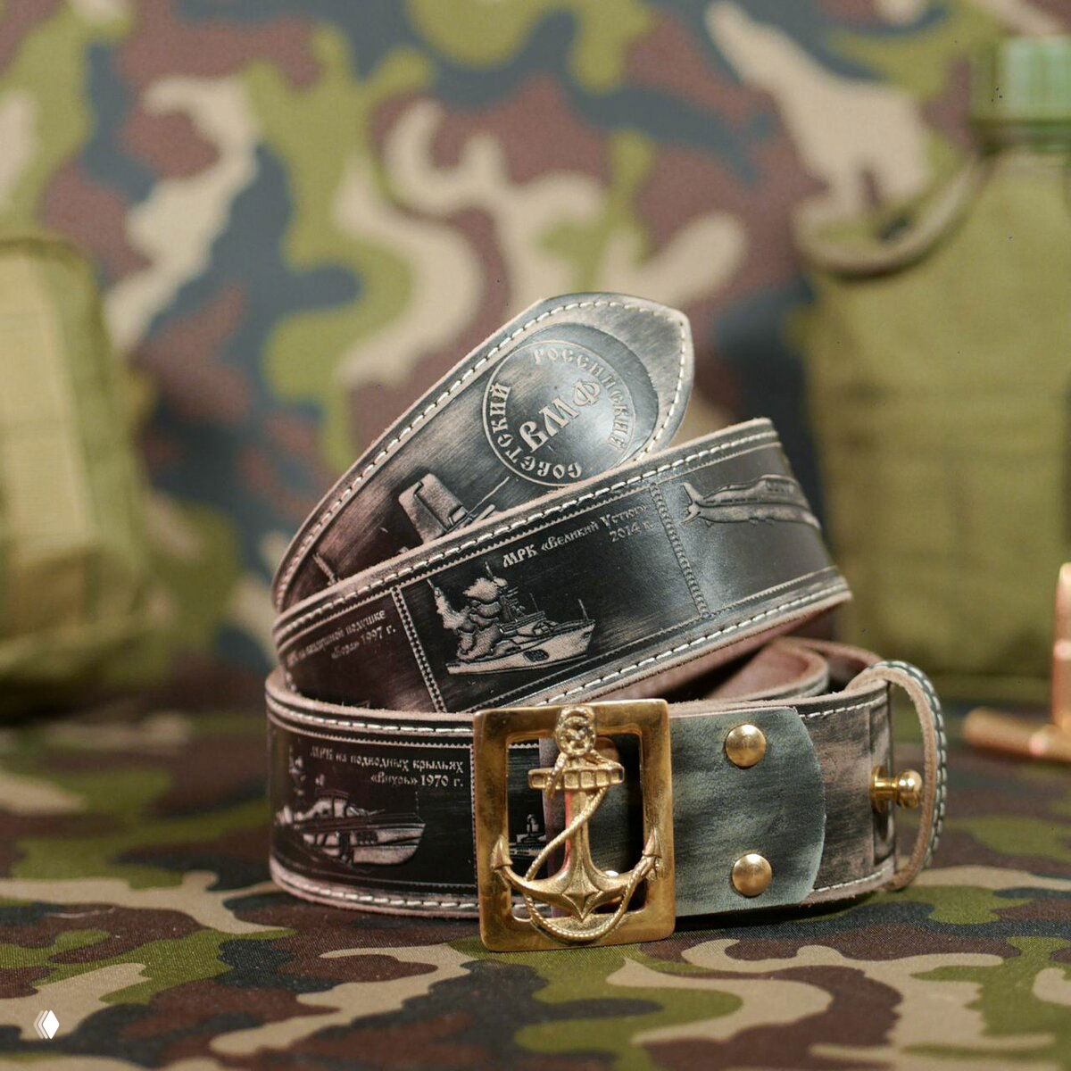 Чёрно-серый ремень с тиснением морской тематики и металлической пряжкой с изображением якоря на камуфляжном фоне.