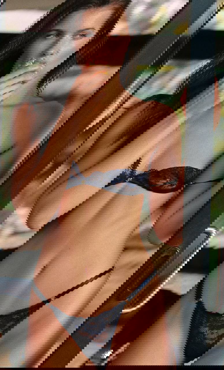 Полнофигураный кадр Кристины Мендонки в тёмно-синем кружевном белье Gooseberry, с фруктом на фоне естественной обстановки.