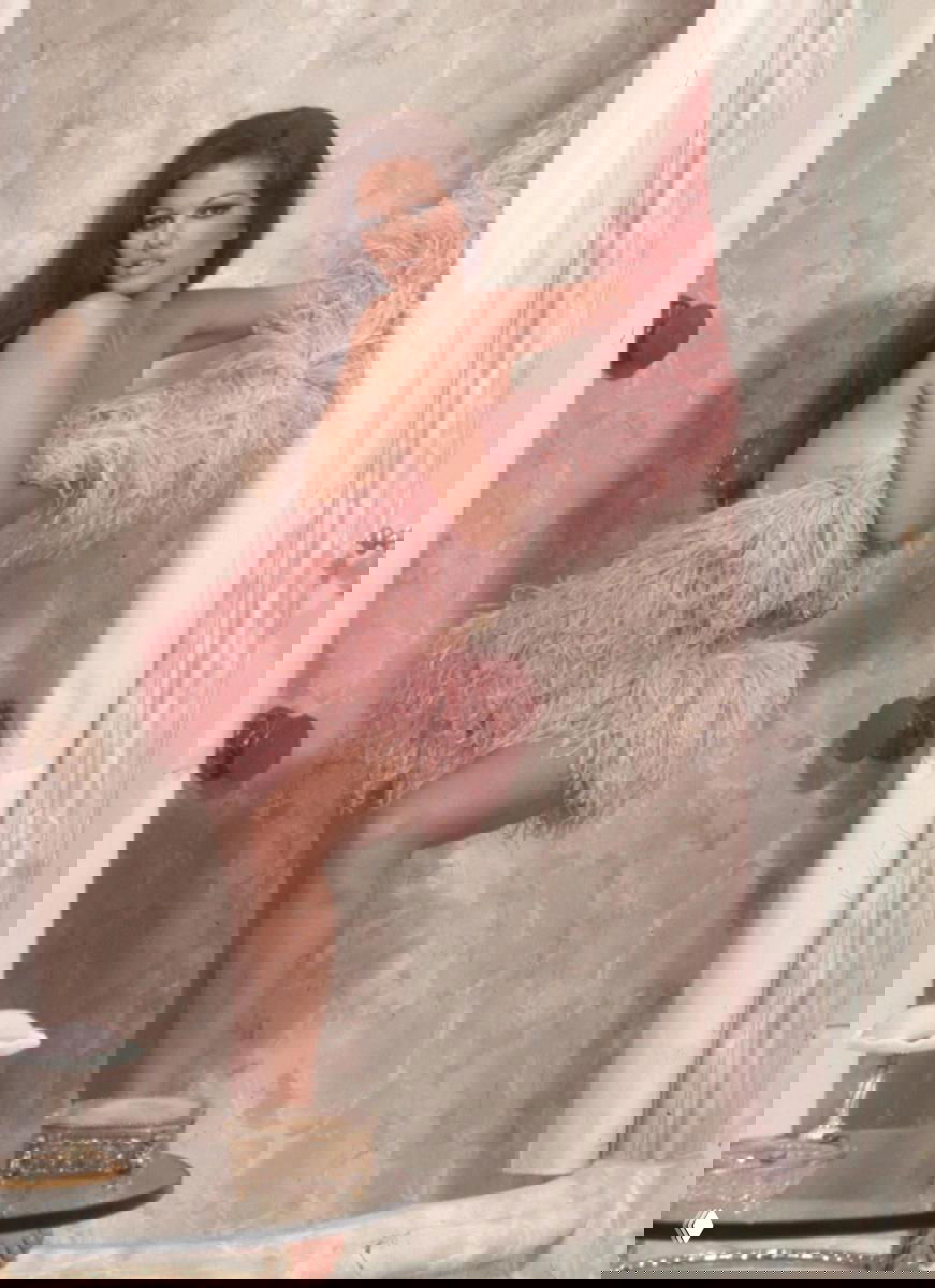 Фотопортрет женщины в розовом перьевом наряде у ванной, гламурная постановка в стиле 60–70-х и элегантная игровая поза.