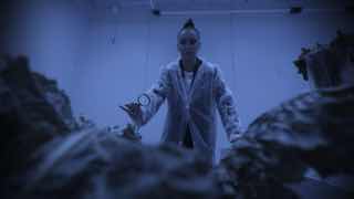 Кадр из третьего сезона: Ольга Бузова в рабочем халате среди растений и сельскохозяйственных помещений, сцена из проекта про аграрное образование.