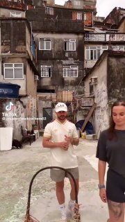 Парень и девушка на фоне многоэтажных зданий фавел: тротуарная площадка, старые фасады и уличная обстановка Рио.