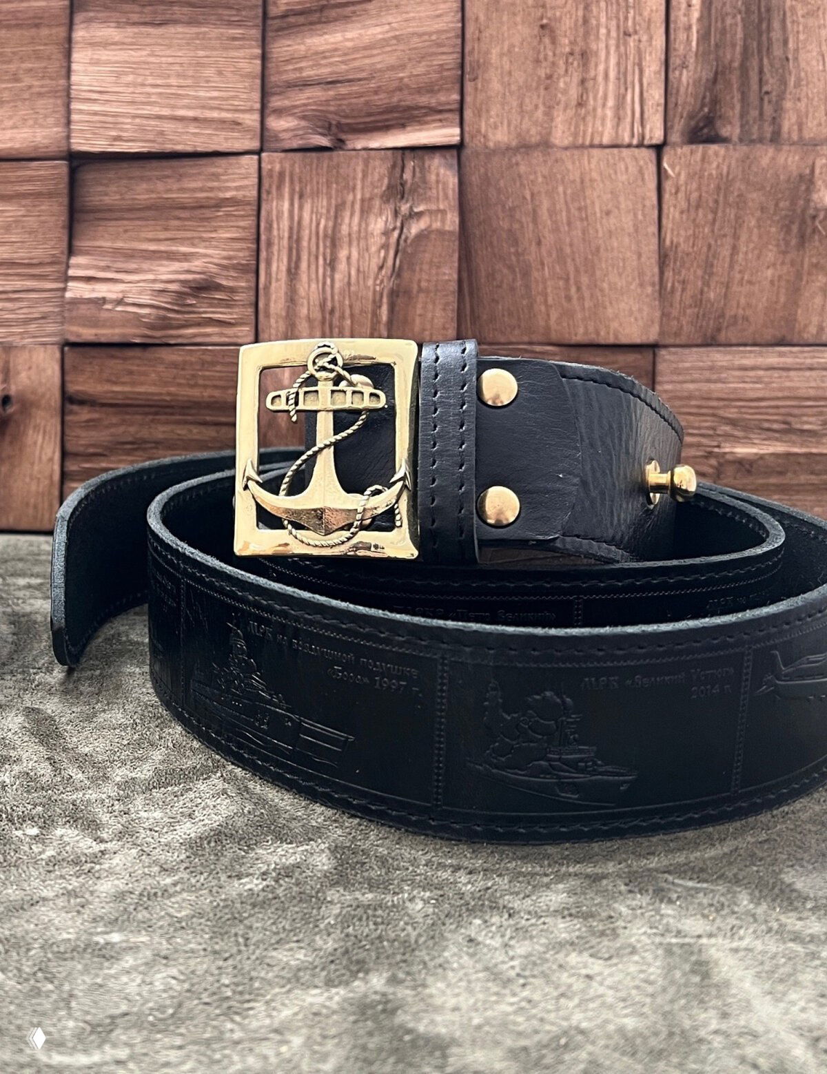 Черный кожаный ремень с пряжкой в форме якоря и тисненым корабельным рисунком на коже — тематическое оформление изделия.