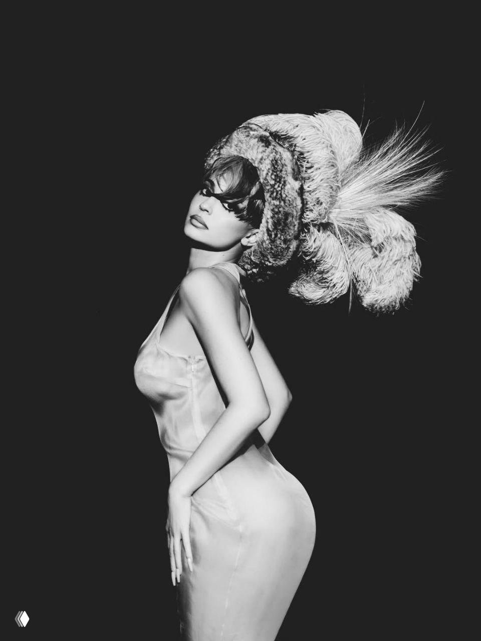 Чёрно‑белый студийный портрет модели в крупной шляпе с перьями; акцент на силуэте, ретро‑макияж и кинематографическая подсветка.