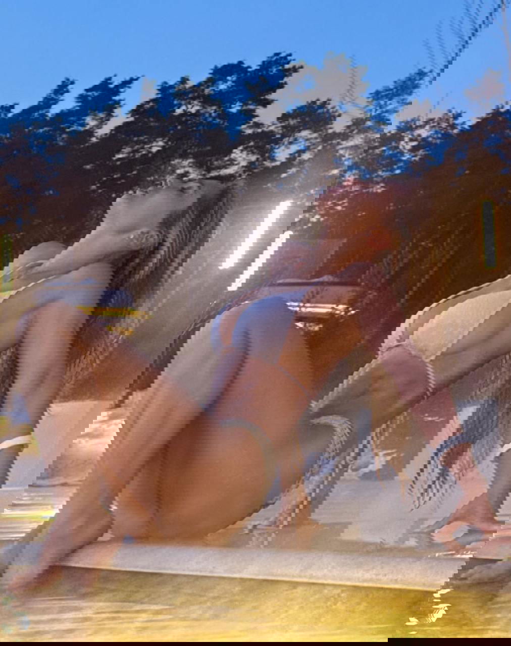 Виктория Цуранова позирует у горячего бассейна в белом купальнике, демонстрируя пресс и гибкость на фоне снега и огней.