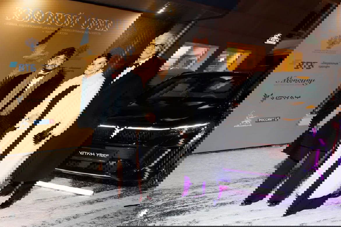 Ковровая дорожка у входа на церемонию «Золотой орёл»: приглашённые в тёплой одежде рядом с электрокаром VOYAH на заснеженной площадке.