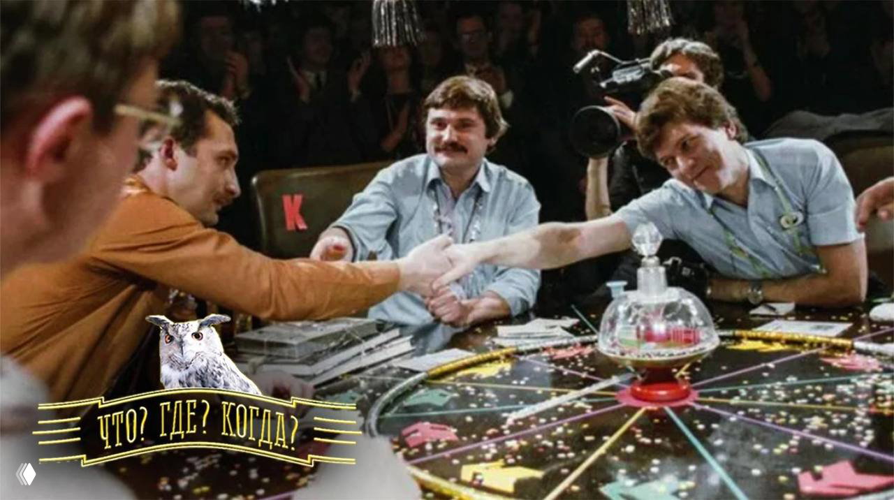Игровой стол и участники советской передачи «Что? Где? Когда?»: игроки, ведущие и операторы в зале, атмосферная ретро-сцена.