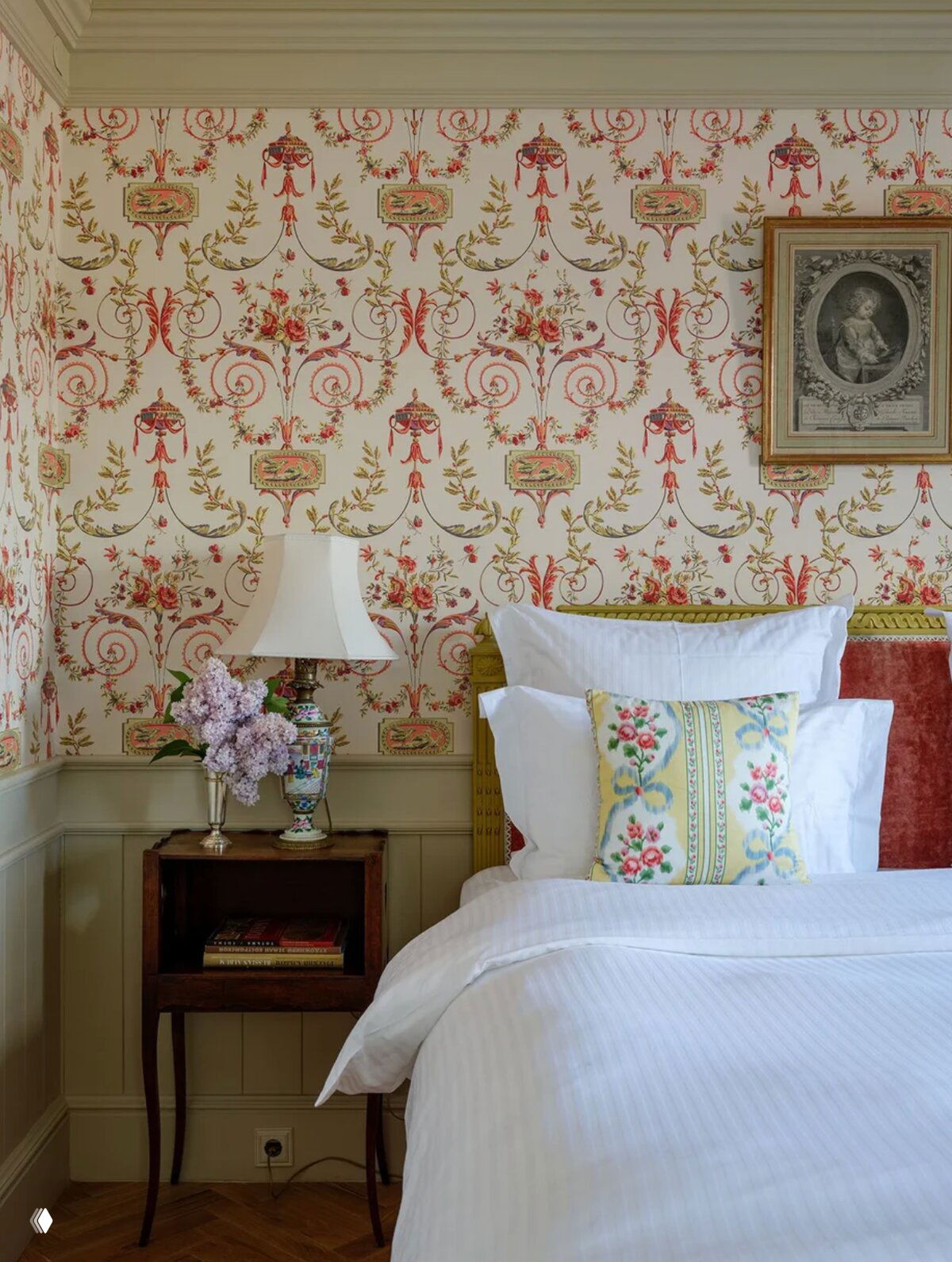 Спальня с цветочными обоями и белым постельным текстилем — уютный интерьер, подходящий для глэмпинга или бутик-отеля.