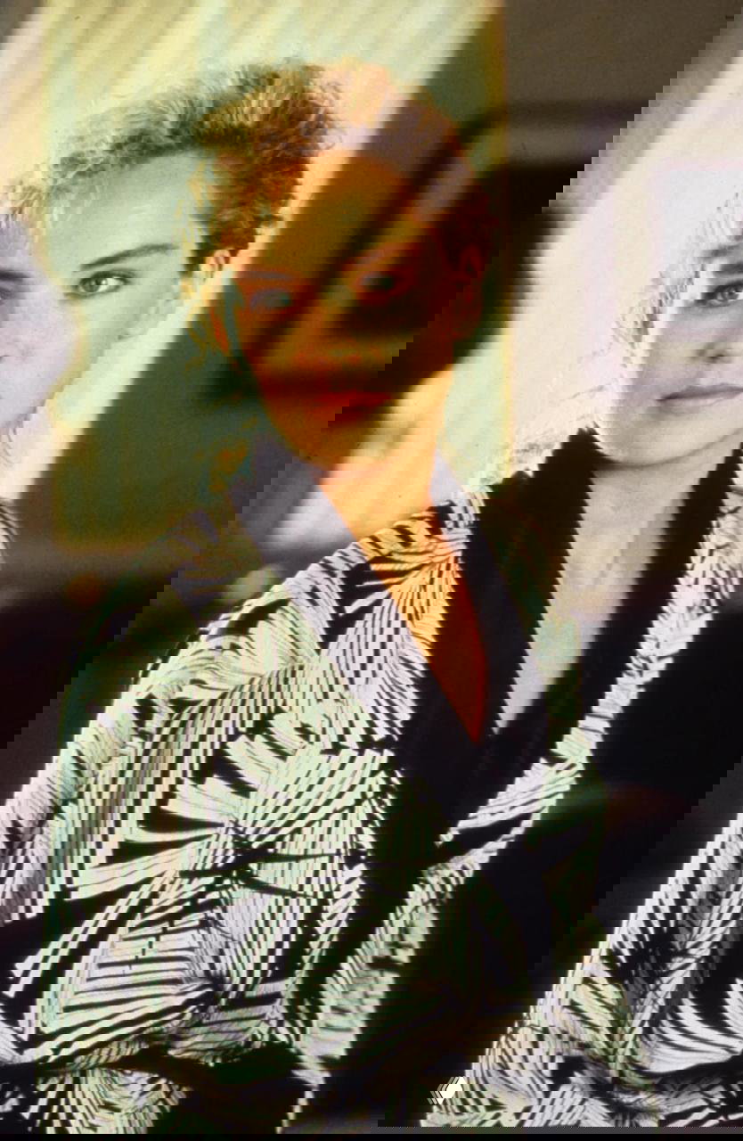 Крупный портретный кадр женщины в лёгком халате на фоне мягкого света — спокойный и выразительный образ киногероини.