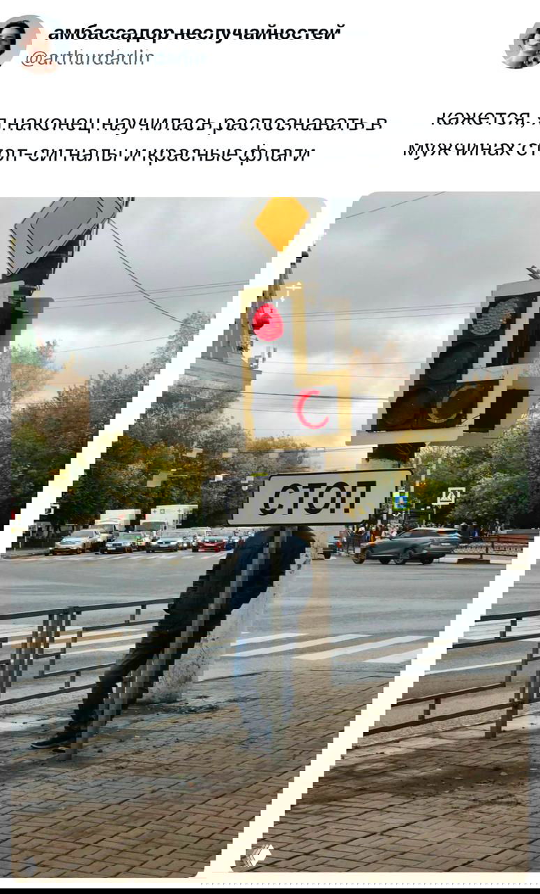 Скриншот твита с фотографией светофора, знаком «СТОП» и человеком у столба — визуальная шутка про «стоп‑сигналы» в мужчинах.