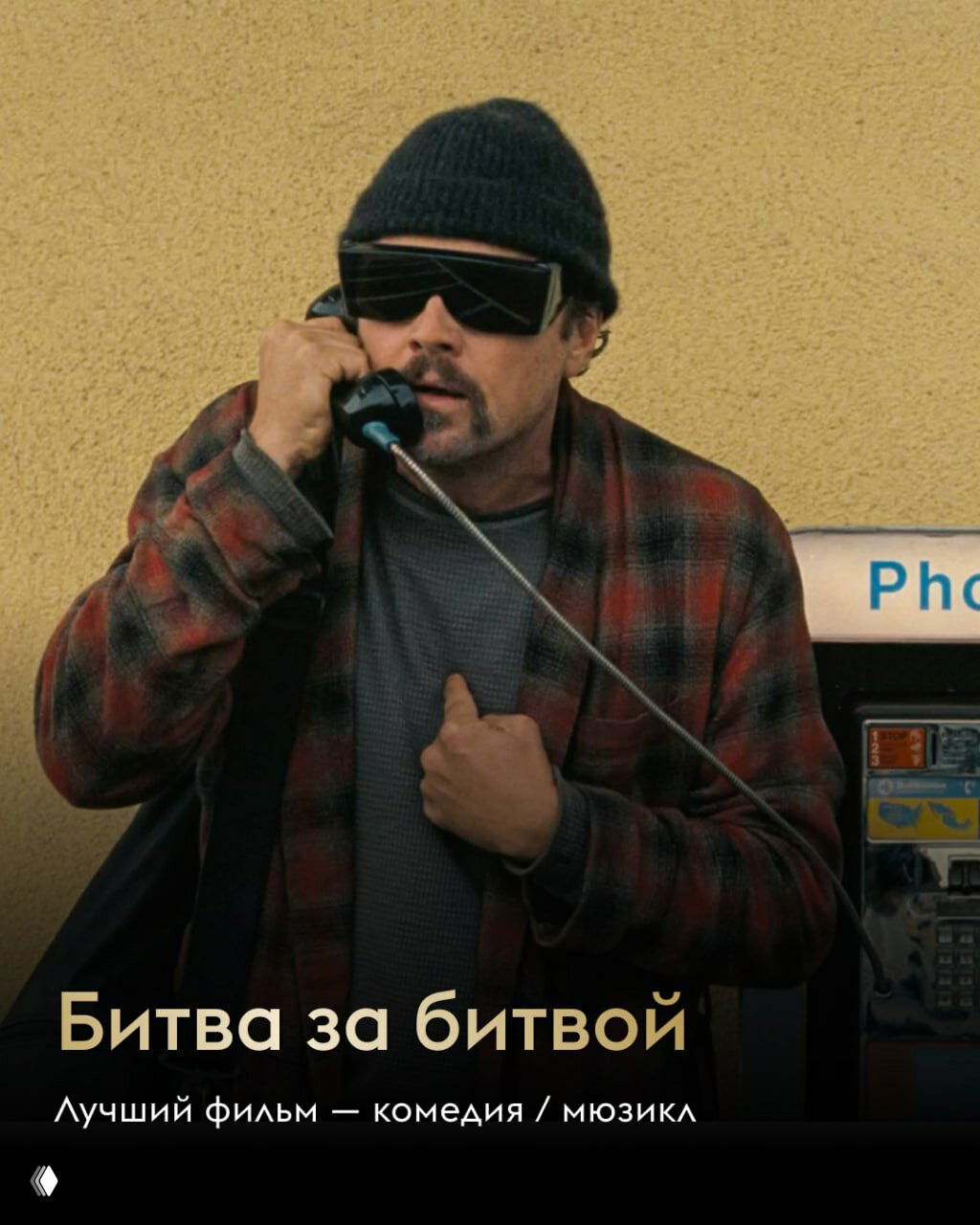 Фото карточки с актёром у телефонной будки в тёмной шапке и очках: образ из фильма с подписью «Битва за битвой», постер лауреата в номинации комедия/мюзикл, картинка церемонии.