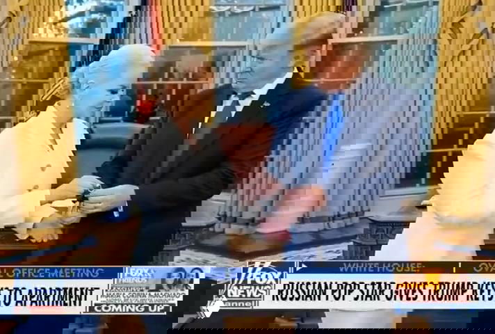 Кадр из кабинета с мужчиной в костюме и женщиной в белом, на переднем плане передача небольшого объекта — монтированный мем о передаче ключей/награды.