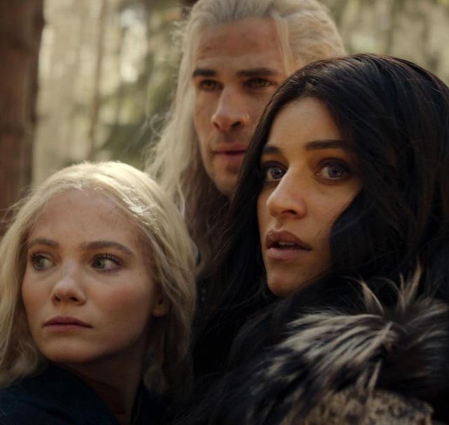 Групповой кадр с Аней Чалотрой и коллегами по «Ведьмаку»: три персонажа в костюмах, напряжённые выражения, лесная или природная сцена сериала.