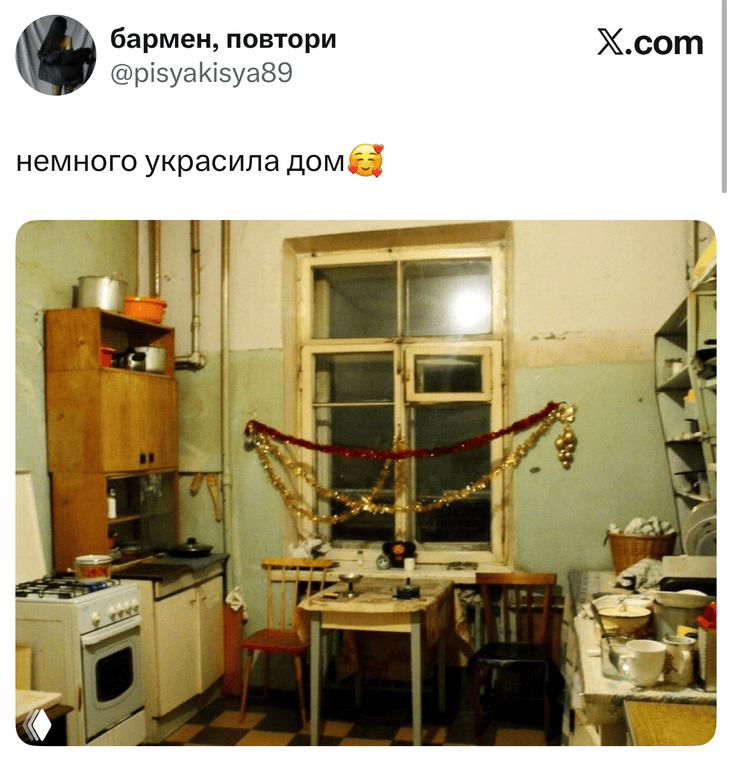 Фотография старой кухни, украшенной гирляндой и мишурой; на фото стол, плита и окно, шутливое оформление интерьера.