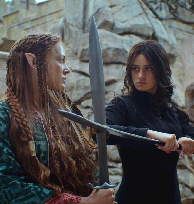 Сценический кадр с Аней Чалотрой с мечом: актриса в динамической позе, напряжённый момент столкновения персонажей во внутреннем пространстве сюжета.