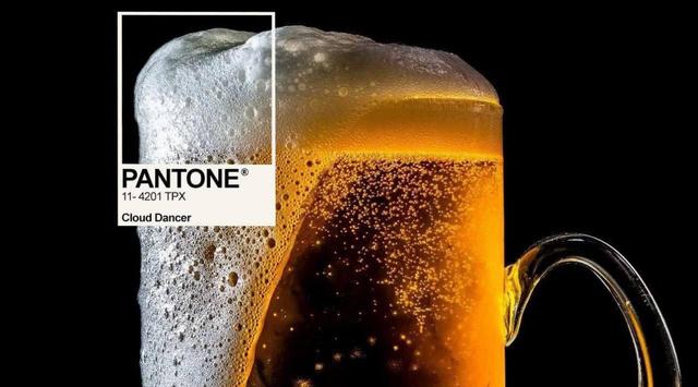 Фотоманипуляция: кружка светлого пива с пеной, к которой добавлен квадратик Pantone и подпись Cloud Dancer — саркастическая мем-версия цвета года.