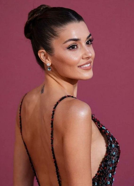 Портрет женщины в вечернем образе в полупрофиль: открытая спина, аккуратная причёска и макияж, снимок с красной дорожки — фокус на профиле.