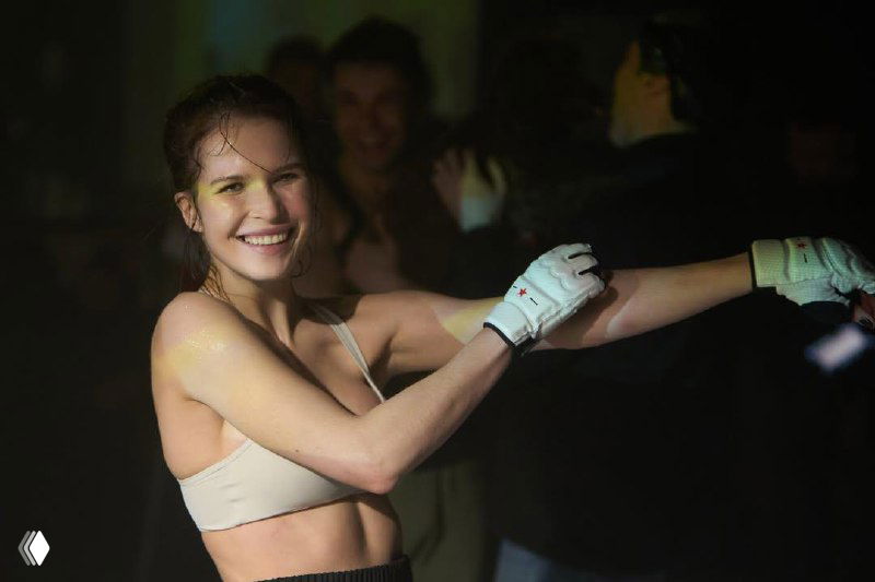 Кадр со съёмок: Лукерья Ильяшенко в движении, ансамбль реквизита и команда на заднем плане, чёрно-белая стилистика