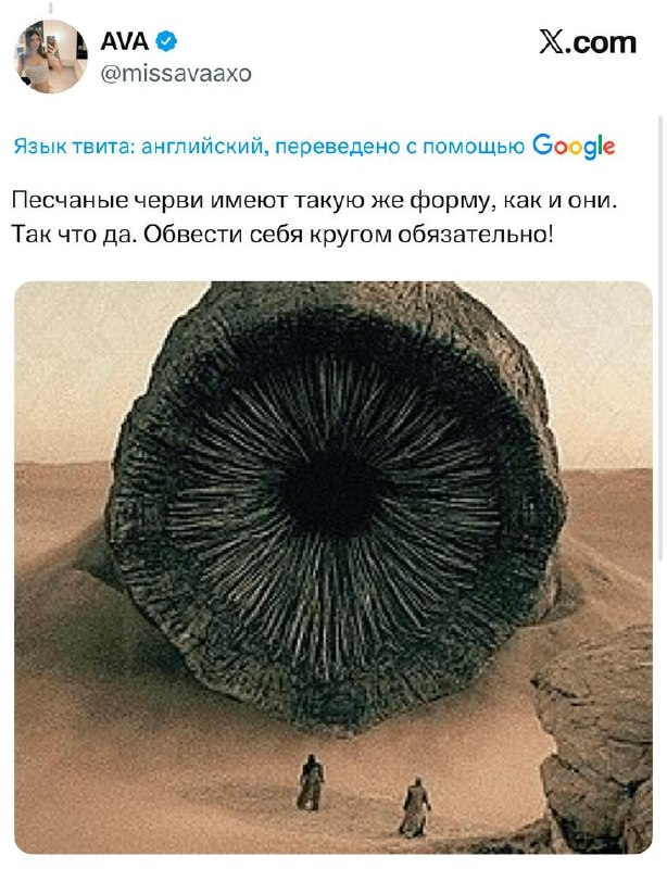 Кадр крупнее: человек в плаще отдыхает на песке в центре круга; на фоне дюна видно ровное очертание линии, проведённой палкой.