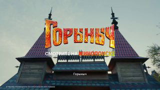 Вывеска с названием фильма «Горыныч» на фасаде сцены/корпуса, рекламный кадр с надписью «Смотрите на Кинопоиске», атмосферный вечерний вид.