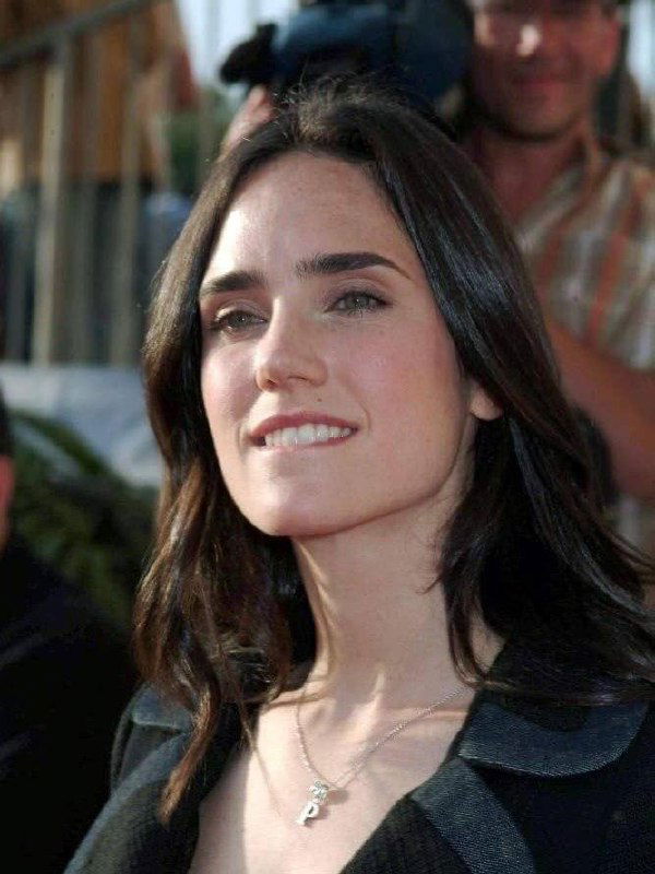 Фото с красной дорожки 90-х: портрет женщины‑актрисы в вечернем образе, заметна улыбка и фон с папарацци и публикой