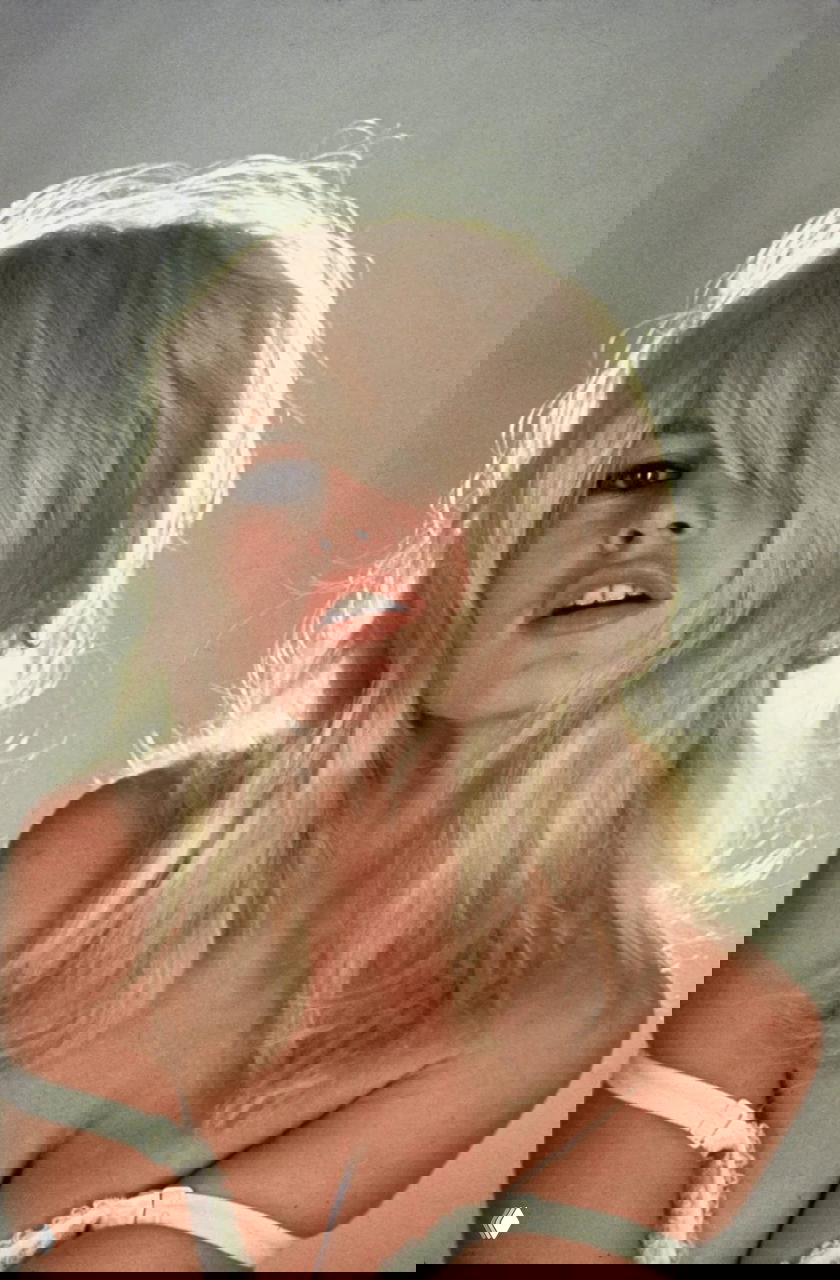 Портрет Бриджит Бардо с распущенными волосами и выразительным взглядом, цветная студийная фотография и крупный план лица и груди.