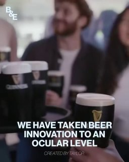 Черные бинокли в форме пивных кружек с логотипом Guinness и белыми крышками, продукт в рекламной подаче на фоне людей на матче.