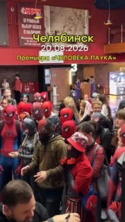 Фойе кинотеатра с собравшимися фанатами в разных вариантах костюма Человека‑паука, видно вывеску с подписью «Челябинск» и дату премьеры.