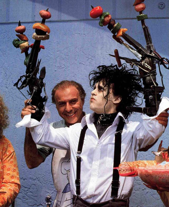 Колоритный фрагмент съёмок: персонаж с механизированными руками-ножницами держит реквизит на фоне декора и съёмочной группы.