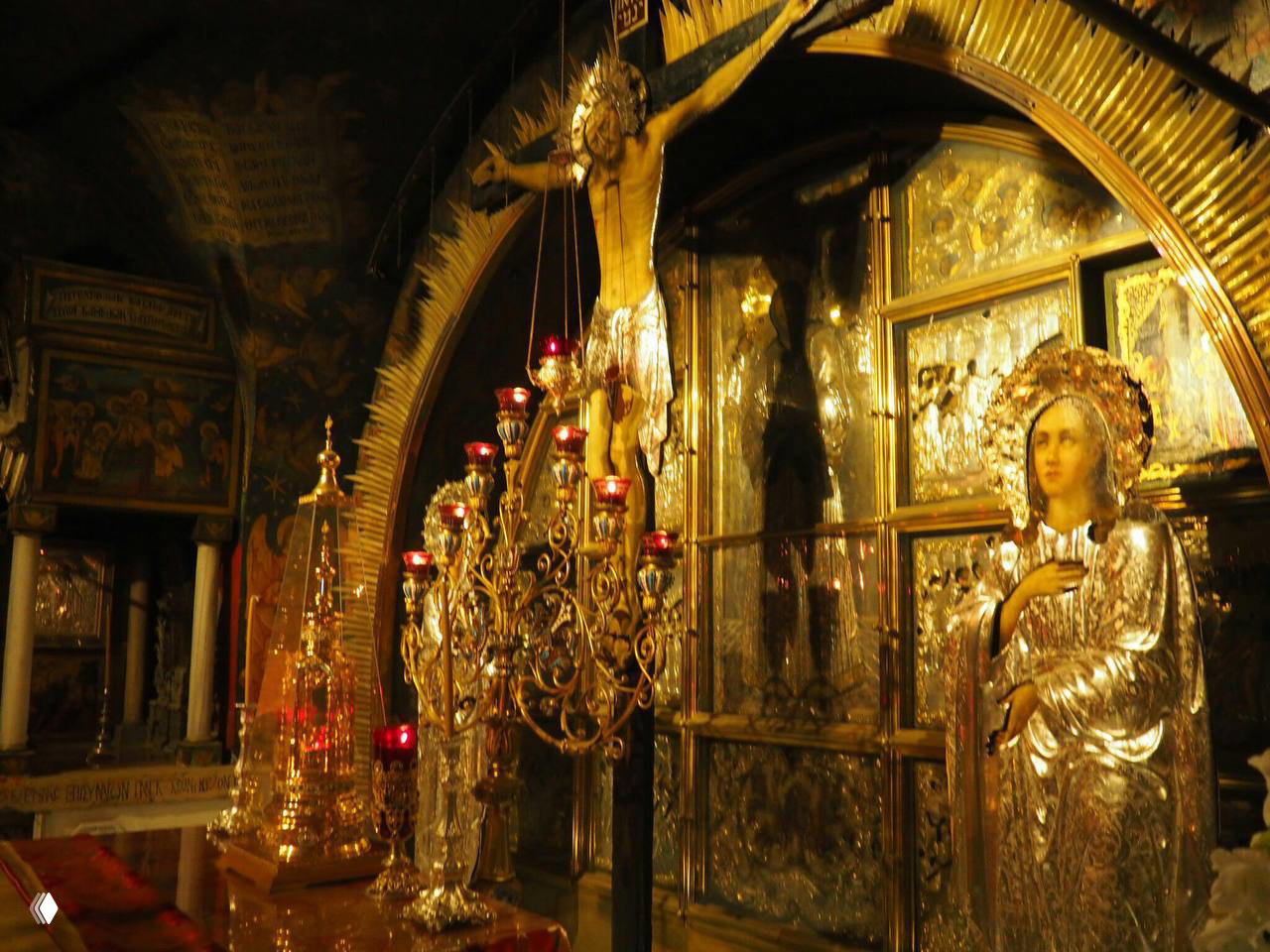 Богато декорированная церковная ризница с иконами и светильниками: золочёные элементы, лампады и религиозные реликвии в храме.