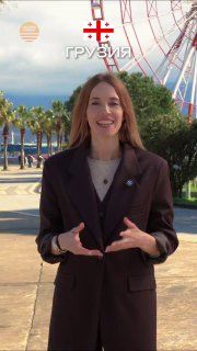 Женщина‑представитель агентства на набережной Батуми на фоне колеса обозрения и пальм; кадр используется для промо островного проекта у Чёрного моря.