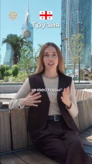 Женщина в деловом наряде на открытой террасе в Батуми на фоне высотных зданий, пальм и городского побережья — иллюстрация ролика о недвижимости.