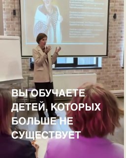 Женщина-преподаватель выступает перед аудиторией у экрана презентации; видны слушатели в зале и наложенный заголовок поста о смене условий обучения.