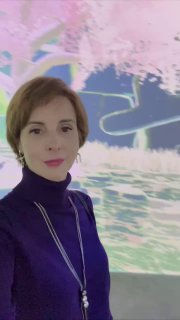 Селфи женщины на фоне инсталляции или выставки с яркими абстрактными цветными элементами — творческий кадр для сторис.