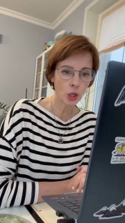 Женщина говорит в веб‑камеру за ноутбуком — рабочий момент онлайн‑встречи или записи контента, деловой формат общения.