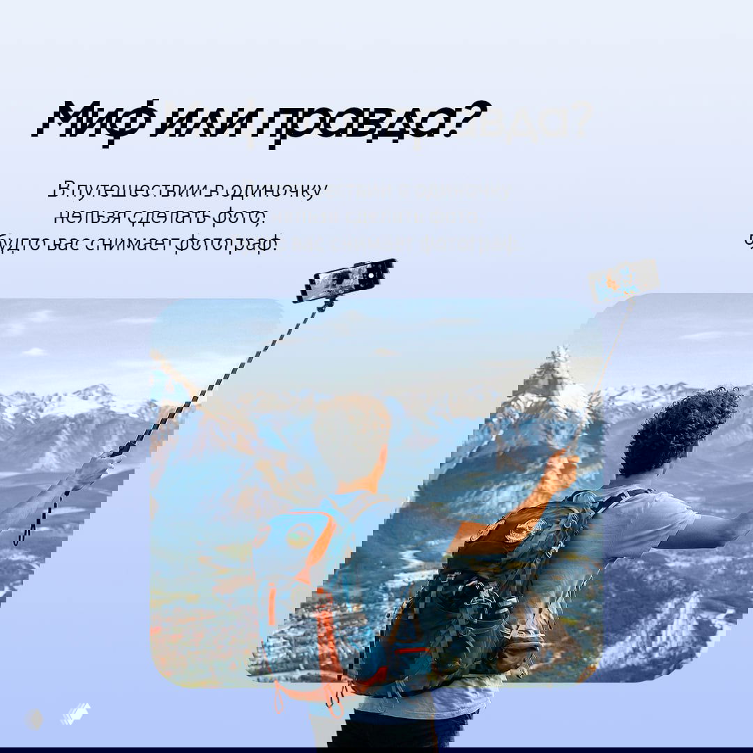 Турист с рюкзаком стоит на вершине и держит телефон на селфи‑палке; в кадре широкие горы и долина, демонстрация съёмки в одиночку.