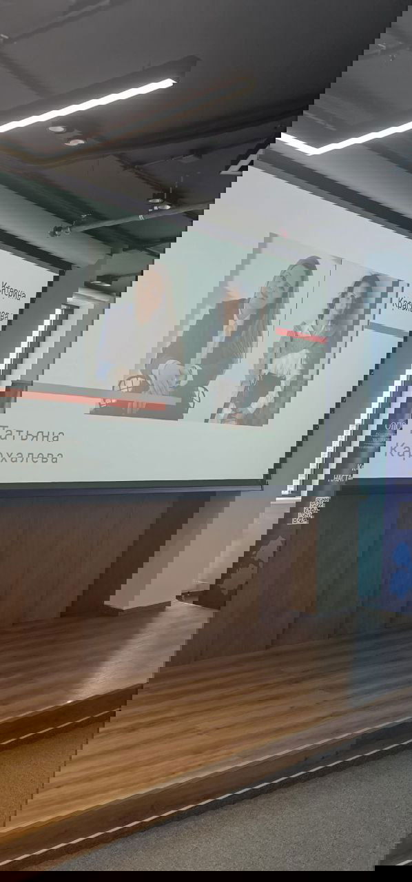 Экран с слайдами и фото спикеров Татьяны Кархалёвой и Катерины Красивовой на сцене мастер‑класса, вид на сцену и проектор.