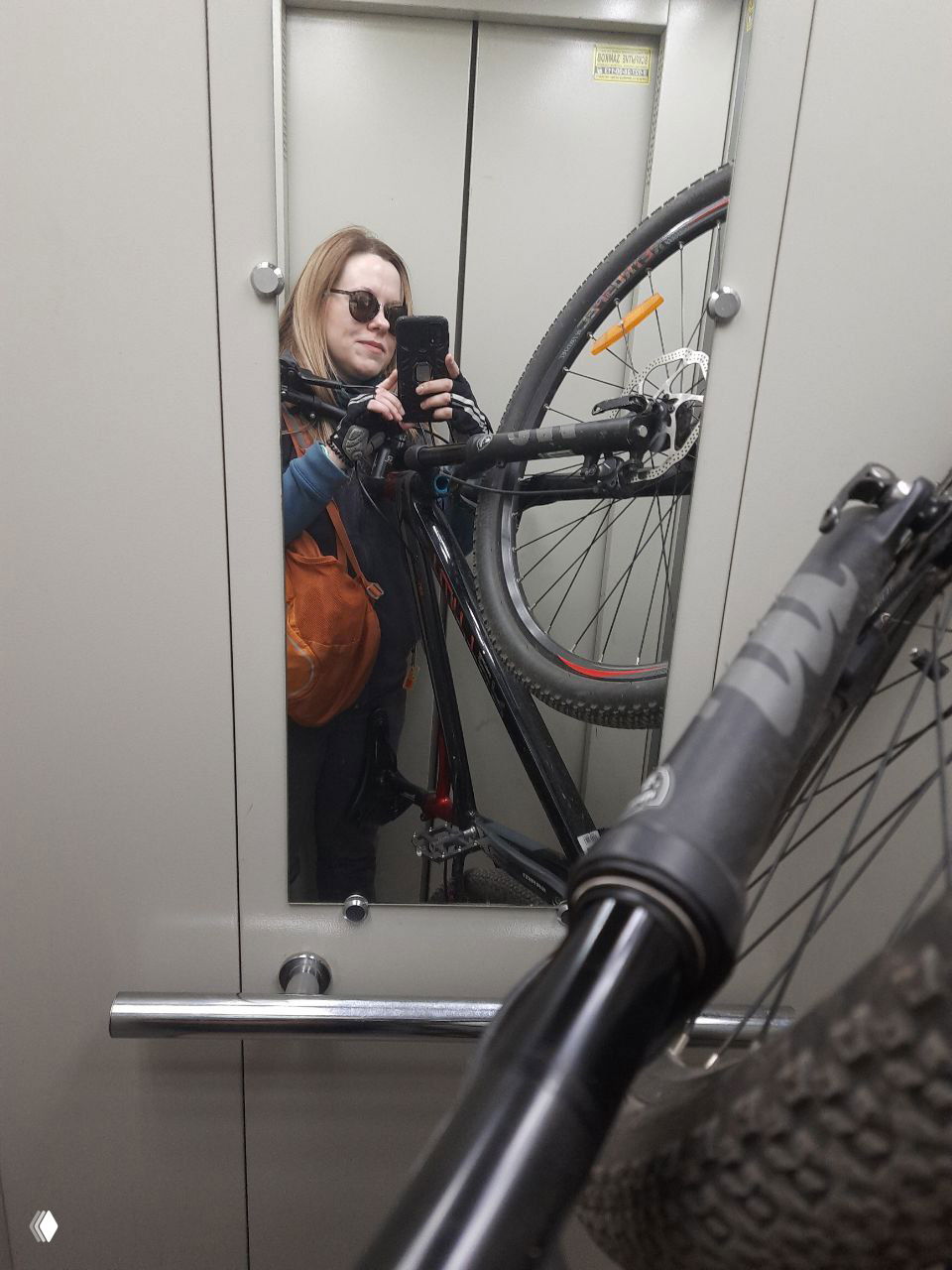 Селфи автора в лифте с частично поднятым велосипедом — кадр показывает транспортировку байка в городской квартире и компактность сборки.