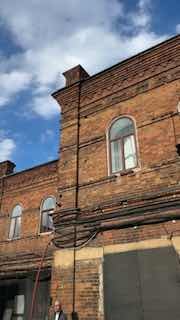 Фасад старого кирпичного дома и голубое небо: кадр создает атмосферу исторической городской среды, где проходят промосъемки и локационные тесты.