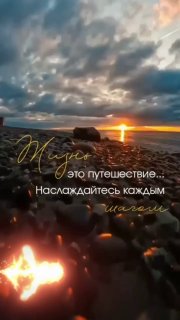 Закат над морским берегом с галькой на переднем плане, тёплый свет, облачное небо и наложенная текстовая надпись.