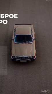 Вид сверху на коричневый ретро‑автомобиль, стоящий на сером асфальте; минималистичное фото с деловой эстетикой и символикой движения и времени.
