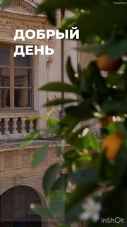 Фасад старого дома с балконом и зелёной листвой на переднем плане; в кадре наложена крупная надпись «ДОБРЫЙ ДЕНЬ», атмосферный уличный ракурс.
