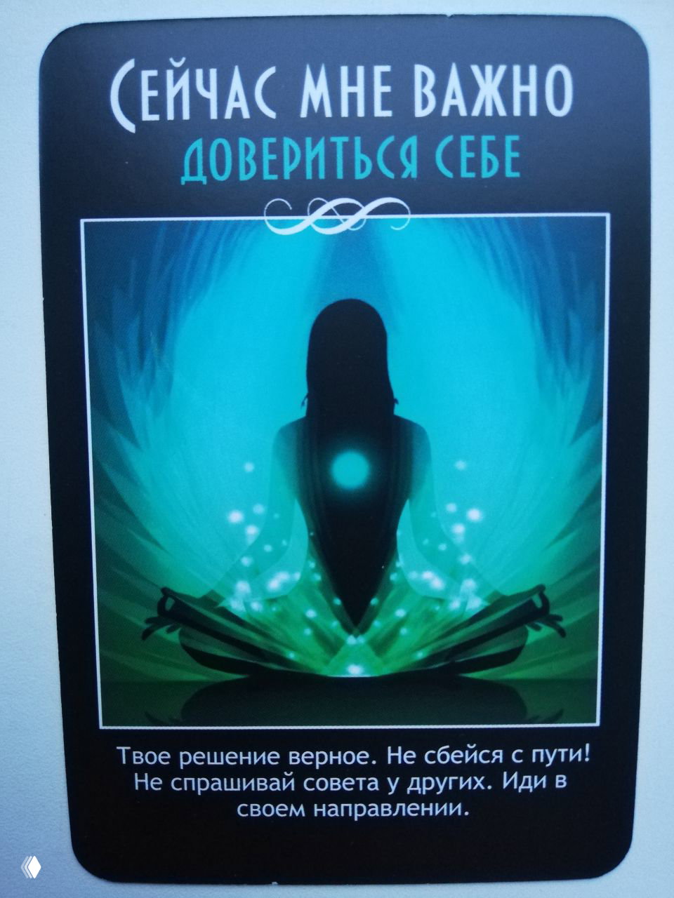 Карта «Довериться себе»: силуэт медитирующей фигуры с подсветкой сердца, сообщение о правильности решения и движении в своём направлении.