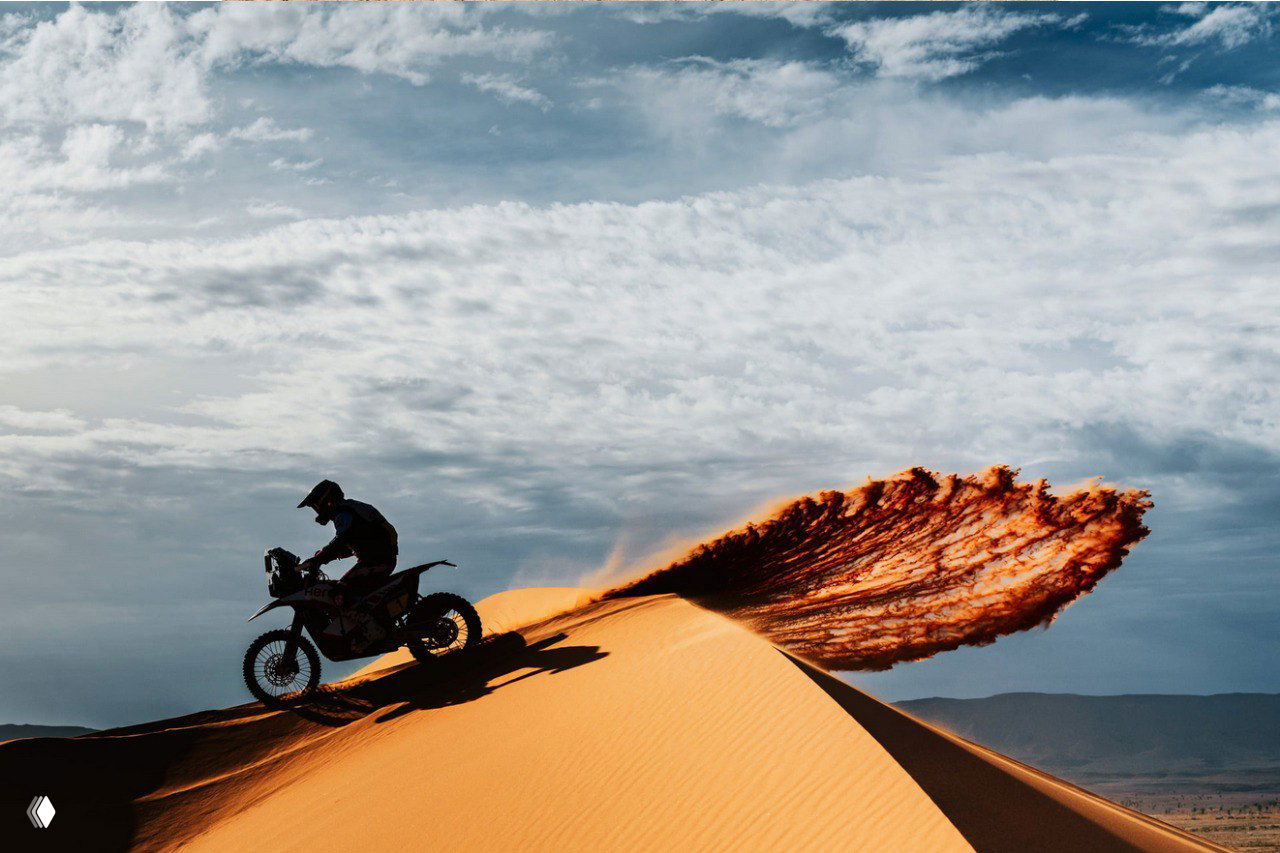 Мотокросс в пустыне: гонщик на дюне создаёт разлетающийся шлейф песка, смелая панорама и контраст между силуэтом и пустынным пейзажем — призовой снимок.