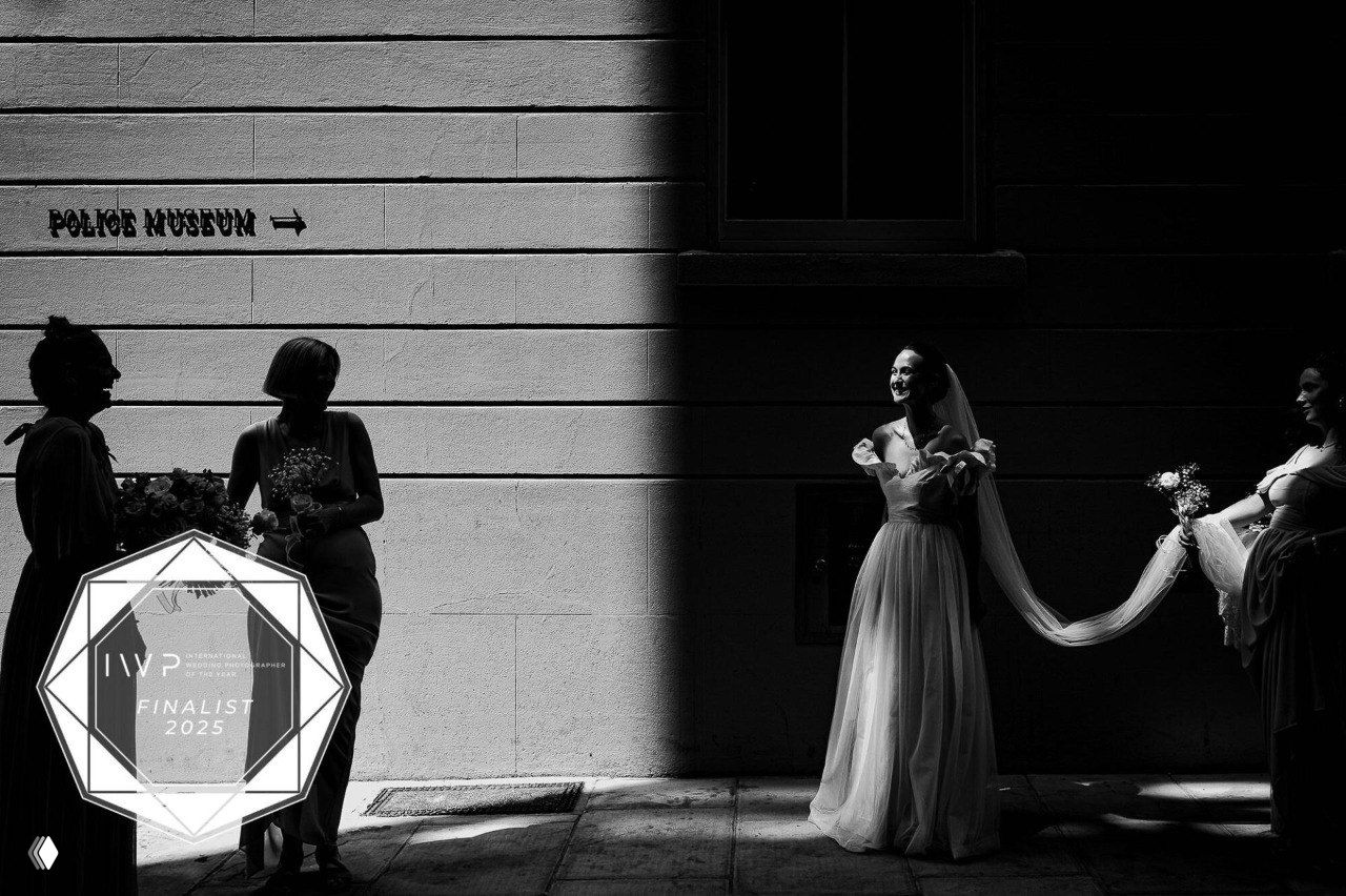 Силуэт невесты с фатой в городском пейзаже, контраст света и тени создаёт графичный свадебный кадр, отмеченный в финале.