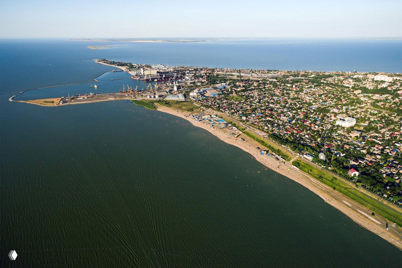 Общий вид Ейска с воздуха: береговая линия, пляжи и грузовой порт с причалами и судами на Азовском море